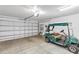 A clean garage with a golf cart, a large roll-up door, and open storage at 4331 Arlington Ridge Blvd, Leesburg, FL 34748