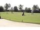 Golf course driving range with players and equipment on a sunny day, perfect for practicing your swing at 4331 Arlington Ridge Blvd, Leesburg, FL 34748