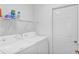 Functional laundry room with a washer and dryer, plus storage shelving at 4331 Arlington Ridge Blvd, Leesburg, FL 34748