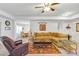 Inviting living room showcasing wood floors, a ceiling fan, a cozy sofa, with a view into the breakfast nook at 4331 Arlington Ridge Blvd, Leesburg, FL 34748