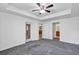 Bright main bedroom featuring a ceiling fan, carpeted floor, and access to an outdoor seating area at 4331 Arlington Ridge Blvd, Leesburg, FL 34748