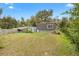 The backyard features a gently sloping lawn, mature trees, and a storage shed on the side at 4552 Cr 300, Lake Panasoffkee, FL 33538
