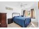 This bedroom is well-lit with light colored walls and a metal bed frame with a blue comforter at 4552 Cr 300, Lake Panasoffkee, FL 33538