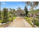 View of long driveway leading to the house with a covered carport and landscaped surroundings at 4552 Cr 300, Lake Panasoffkee, FL 33538