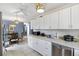 Bright kitchen featuring white cabinets, tile countertops and backsplash, and stainless steel dishwasher at 4552 Cr 300, Lake Panasoffkee, FL 33538