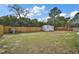 Spacious backyard featuring a wooden fence, a storage shed, and lush green grass at 50 Pecan Run Crse, Ocala, FL 34472