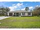 Charming single-story home featuring a well-kept lawn, a brown garage door, and a stone walkway at 50 Pecan Run Crse, Ocala, FL 34472