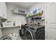 Well-equipped laundry room with modern washer, dryer, storage shelves, and patterned tile flooring at 50 Pecan Run Crse, Ocala, FL 34472