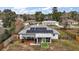 Aerial view of home with solar panels, deck, and screened porch, nestled in lush greenery at 50 Pecan Run Crse, Ocala, FL 34472