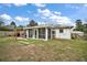 The home's rear exterior shows a screened porch, a wooden deck, and a well-maintained yard at 50 Pecan Run Crse, Ocala, FL 34472