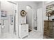 Bright bathroom featuring white cabinets, decorative clock, and a shower with a neutral shower curtain at 5121 Aurora Dr, Leesburg, FL 34748