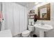 Cozy bathroom with a toilet, sink, and framed mirror at 5121 Aurora Dr, Leesburg, FL 34748