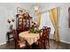 Dining room features wood floors, chandelier, and a wooden china cabinet near the window at 5121 Aurora Dr, Leesburg, FL 34748