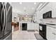 Well-lit kitchen featuring white cabinets, stainless steel appliances, and a view into the dining area at 5121 Aurora Dr, Leesburg, FL 34748