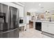 Kitchen showcasing stainless steel appliances, white cabinetry, and open access to the dining area at 5121 Aurora Dr, Leesburg, FL 34748