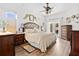 Spacious main bedroom with hardwood flooring, a ceiling fan, and natural lighting at 5121 Aurora Dr, Leesburg, FL 34748