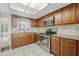 Well-lit kitchen with stainless steel appliances, wood cabinetry, granite countertops, and tile flooring at 516 Spring Oaks Blvd, Altamonte Springs, FL 32714