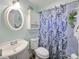 Bathroom featuring a classic vanity, round mirror, and a shower with a patterned blue curtain at 6106 Kittiwake Dr, Lakeland, FL 33809