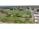 Scenic aerial view of a golf course featuring manicured greens, sand traps, and tranquil ponds amid a residential area at 6106 Kittiwake Dr, Lakeland, FL 33809