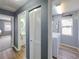 Hallway view with a bathroom and laundry room, featuring wooden floors and neutral paint colors at 6106 Kittiwake Dr, Lakeland, FL 33809