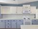 Close-up of the kitchen area with white appliances and two-tone cabinets beneath a white countertop at 6106 Kittiwake Dr, Lakeland, FL 33809