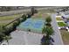 Aerial view of well-maintained tennis courts with lighting, surrounded by parking spaces and greenery, adjacent to a road at 6106 Kittiwake Dr, Lakeland, FL 33809