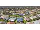 Wide aerial view of a neighborhood with lush landscaping, well-maintained lawns, and diverse roof colors on single-Gathering homes at 613 Sherwood St, The Villages, FL 32162