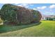 A backyard view showing the back side of the house with trees and a lush green lawn at 613 Sherwood St, The Villages, FL 32162