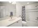 Bathroom featuring marble countertop, white cabinets, large mirror, and shower/tub combination at 613 Sherwood St, The Villages, FL 32162