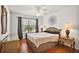 Bright bedroom with a queen bed, stylish side tables, and hardwood floors at 613 Sherwood St, The Villages, FL 32162