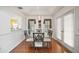 Bright dining room features modern chandelier, glass table, and decorative window treatments at 613 Sherwood St, The Villages, FL 32162