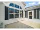 A detailed view of the home's screened-in porch, featuring a brick paver patio at 613 Sherwood St, The Villages, FL 32162