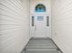 Close-up of the front door with sidelights and transom window and gray tile landing at 613 Sherwood St, The Villages, FL 32162