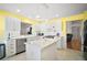 White kitchen with stainless steel appliances, tiled backsplash, island, and breakfast bar at 613 Sherwood St, The Villages, FL 32162