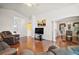 Open concept living area with hardwood floors, ceiling fan, and adjacent dining area at 613 Sherwood St, The Villages, FL 32162