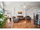 Bright living room featuring wood floors, comfortable furniture, and view to bedroom at 613 Sherwood St, The Villages, FL 32162