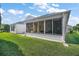 This screened porch overlooks the lush green backyard and features full screens at 613 Sherwood St, The Villages, FL 32162