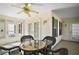 Enclosed sun room featuring white walls, tile floor, ceiling fan, and a glass table with four chairs at 613 Sherwood St, The Villages, FL 32162