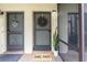 Inviting front entryway featuring a decorative wreath, welcome mat, and a well-lit entrance at 7266 Swallow Run # 7266, Winter Park, FL 32792