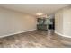 Spacious living room showcasing wood floors and a view of the adjacent kitchen with black appliances at 7266 Swallow Run # 7266, Winter Park, FL 32792