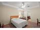 Cozy bedroom with a comfortable bed, neutral walls, carpet floors and natural light, adjacent to the bathroom at 7528 Park Hill Ave, Leesburg, FL 34748