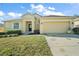 Inviting one-story home featuring a well-kept lawn, attached garage, and yellow facade at 7528 Park Hill Ave, Leesburg, FL 34748