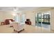 Bright living room with tiled floors, a ceiling fan, and sliding glass doors leading to the backyard at 7528 Park Hill Ave, Leesburg, FL 34748