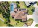 Aerial view of the house, screened pool, solar panels and manicured lawn in a lush green neighborhood at 7885 Se 166Th Hibernia Ln, The Villages, FL 32162