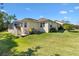 Lush backyard featuring a screened-in lanai, staircase, well-maintained lawn, and mature landscaping at 7885 Se 166Th Hibernia Ln, The Villages, FL 32162