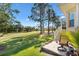 Scenic backyard with a brick patio overlooking a well-manicured lawn and picturesque golf course at 7885 Se 166Th Hibernia Ln, The Villages, FL 32162