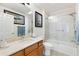 Bathroom featuring wood cabinets, granite countertop, and glass enclosed shower at 7885 Se 166Th Hibernia Ln, The Villages, FL 32162