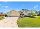 Charming single-story home featuring a well-manicured lawn, beautiful landscaping, and a spacious three-car garage at 7885 Se 166Th Hibernia Ln, The Villages, FL 32162