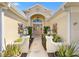 Inviting front entrance with stone pathway, decorative lighting, and lush landscaping creating a warm, welcoming ambiance at 7885 Se 166Th Hibernia Ln, The Villages, FL 32162