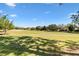 Scenic view of a meticulously maintained golf course with mature trees and blue skies at 7885 Se 166Th Hibernia Ln, The Villages, FL 32162